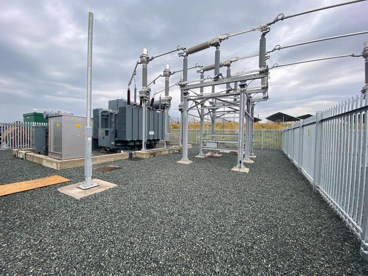 Grayscale outdoor high voltage substation with transformer and bars